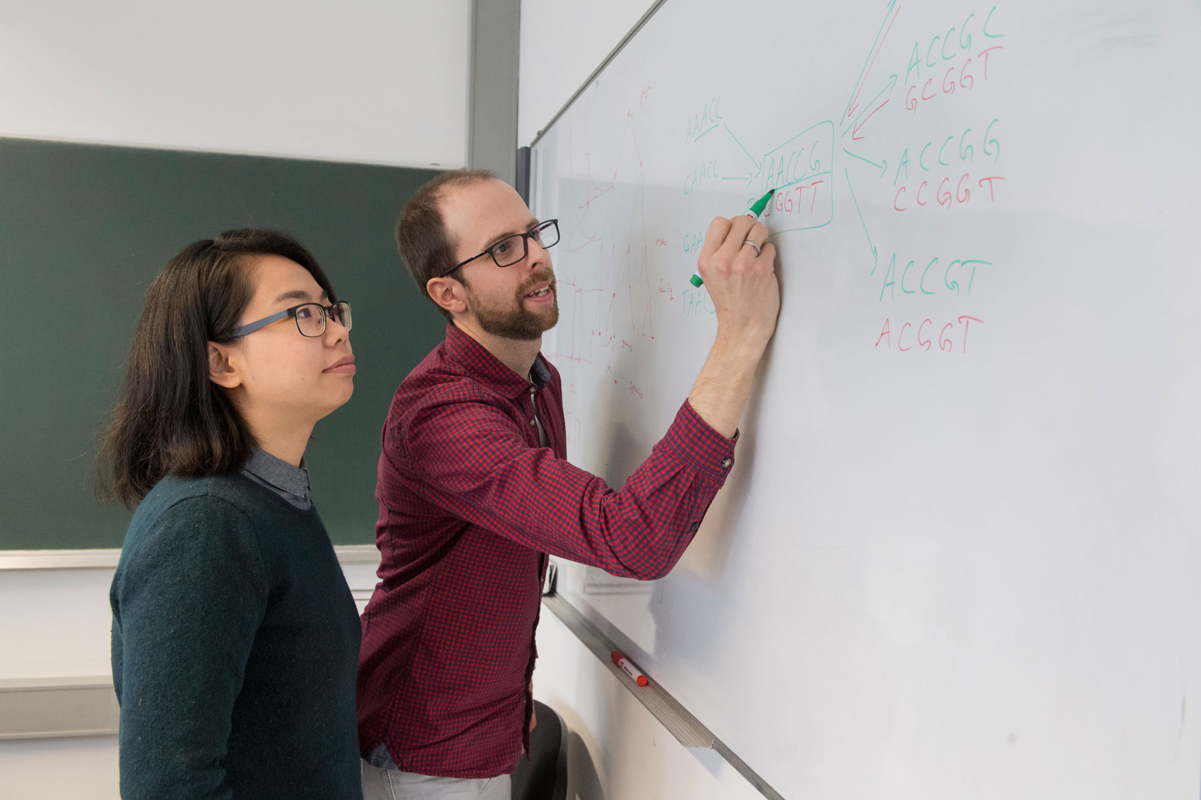 Frau und Mann schreiben an Whiteboard