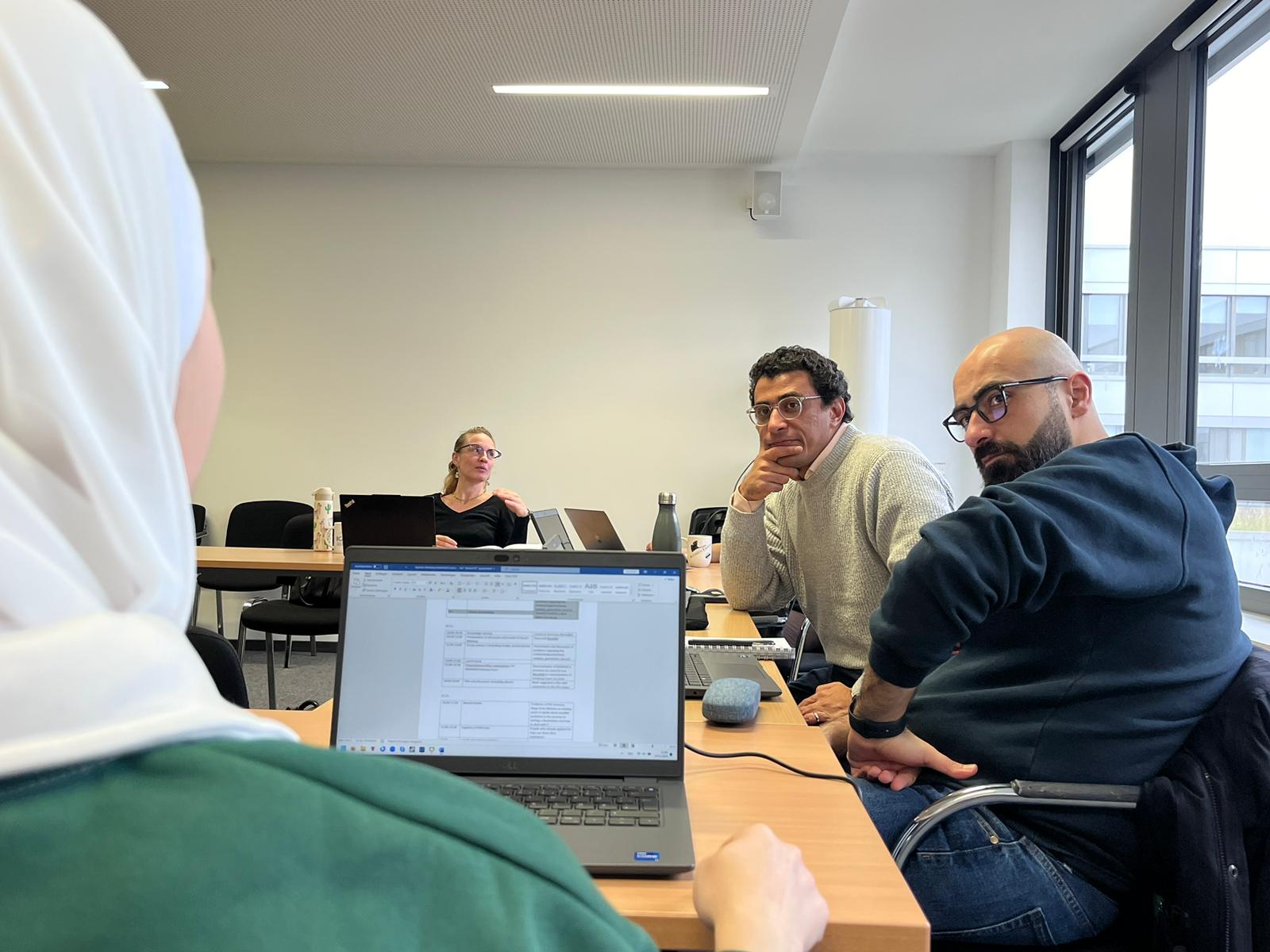 Researchers talking to each other in a conference room.