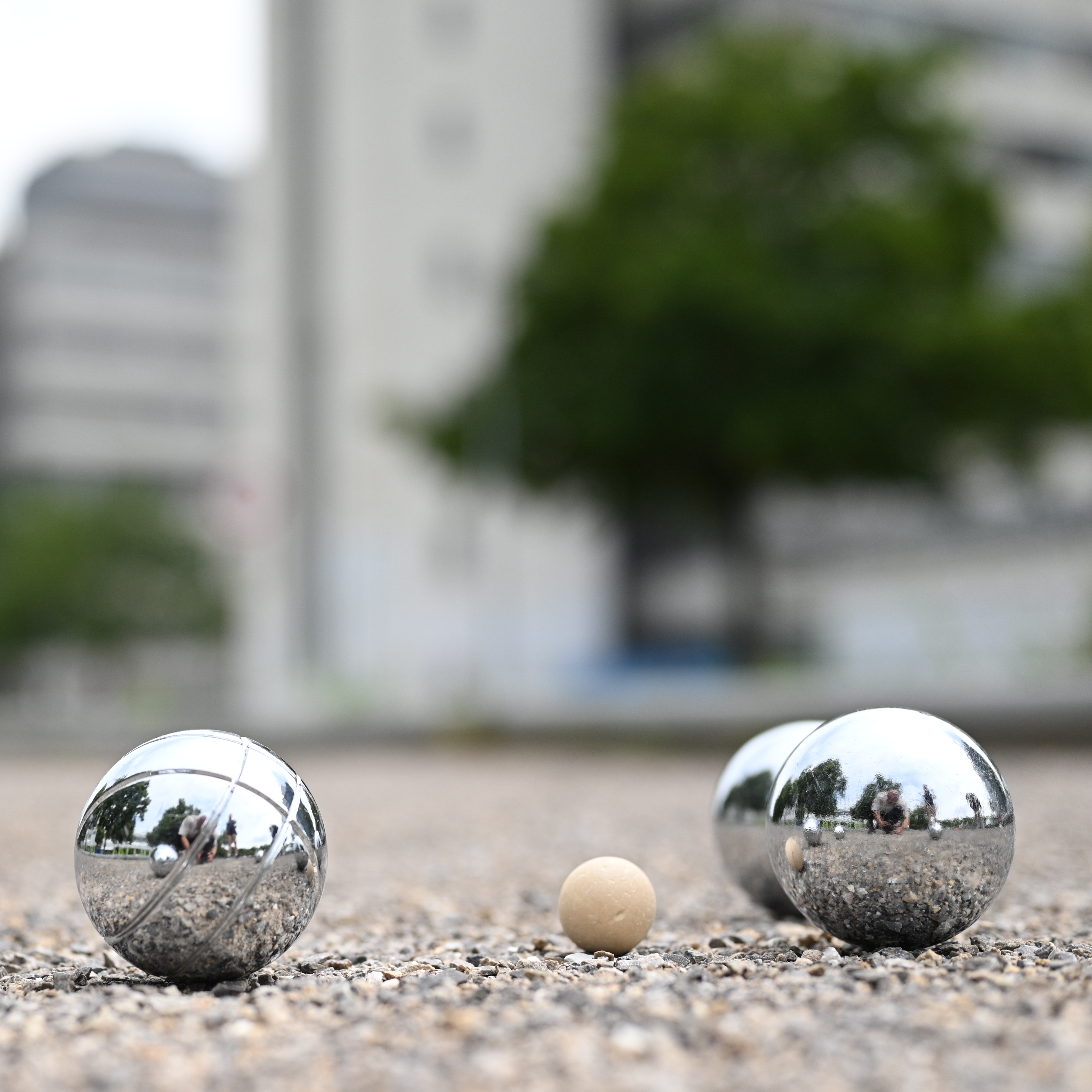 Foto zeigt Boulekugeln auf dem Bouleplatz, im Hintergrund ist das Universitätshauptgebäude zu sehen