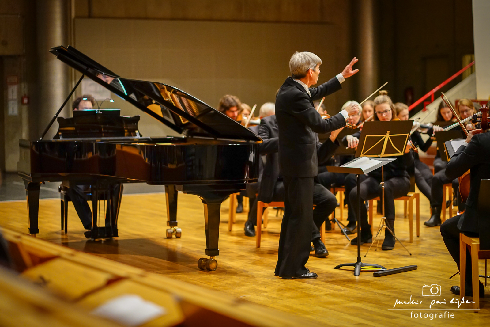 Der Dirigent steht vor dem Orchester