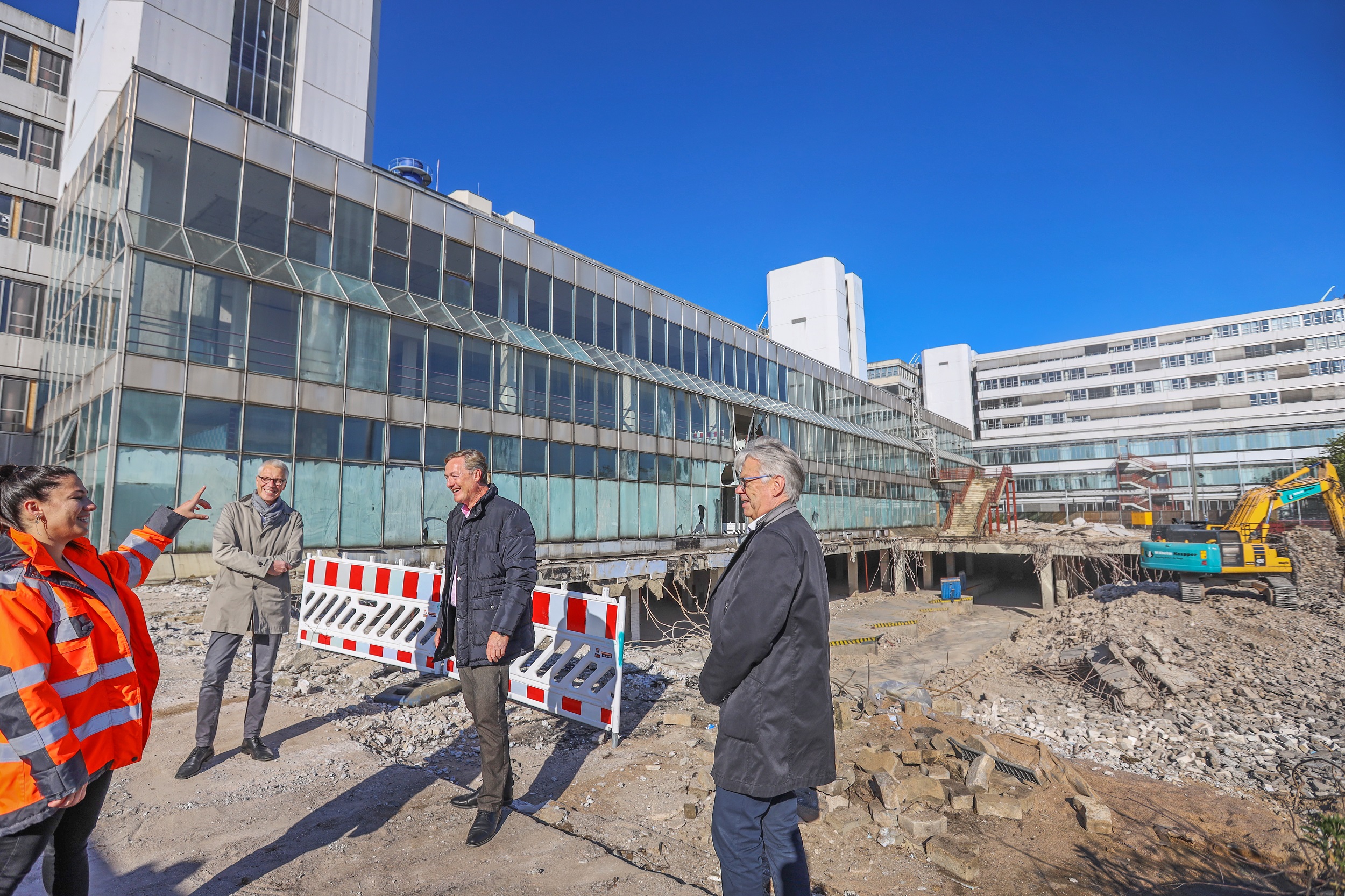 Beteiligte Personen im Gespräch, im Hintergrund die Baustelle