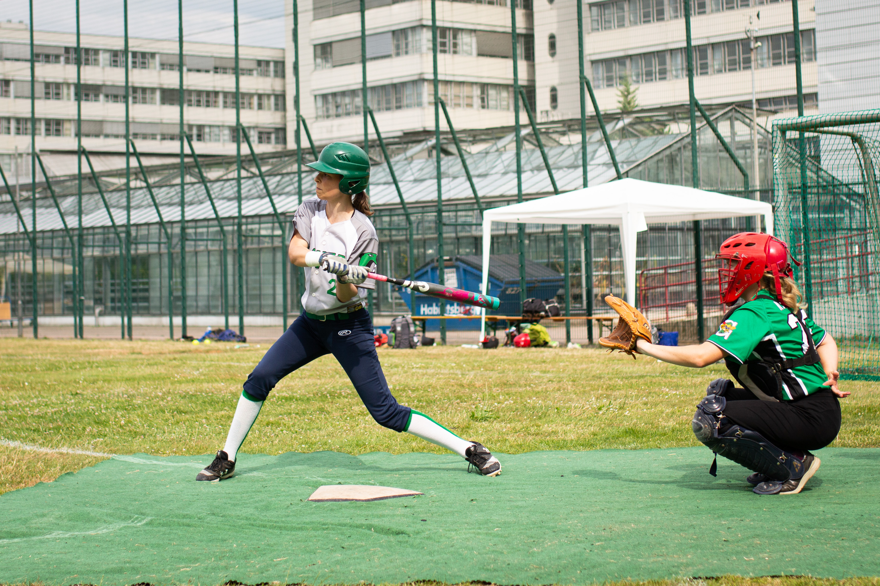 eine Spielerin steht an der Homeplate und holt zum Schlag aus