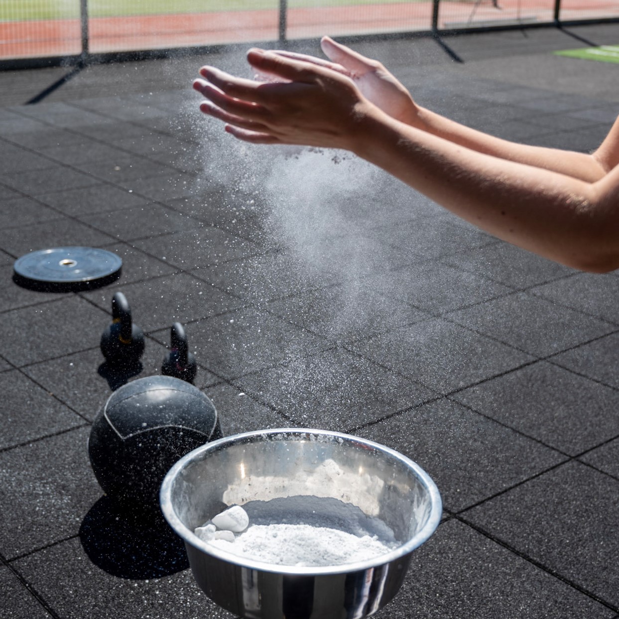 Foto von Hnden mit Chalk und Kettlebells im Hintergrund