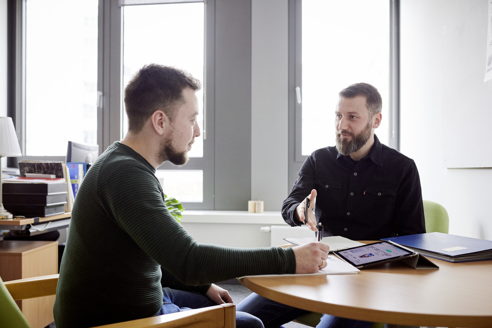 Zwei Personen sitzen sich gegenüber und beraten sich.