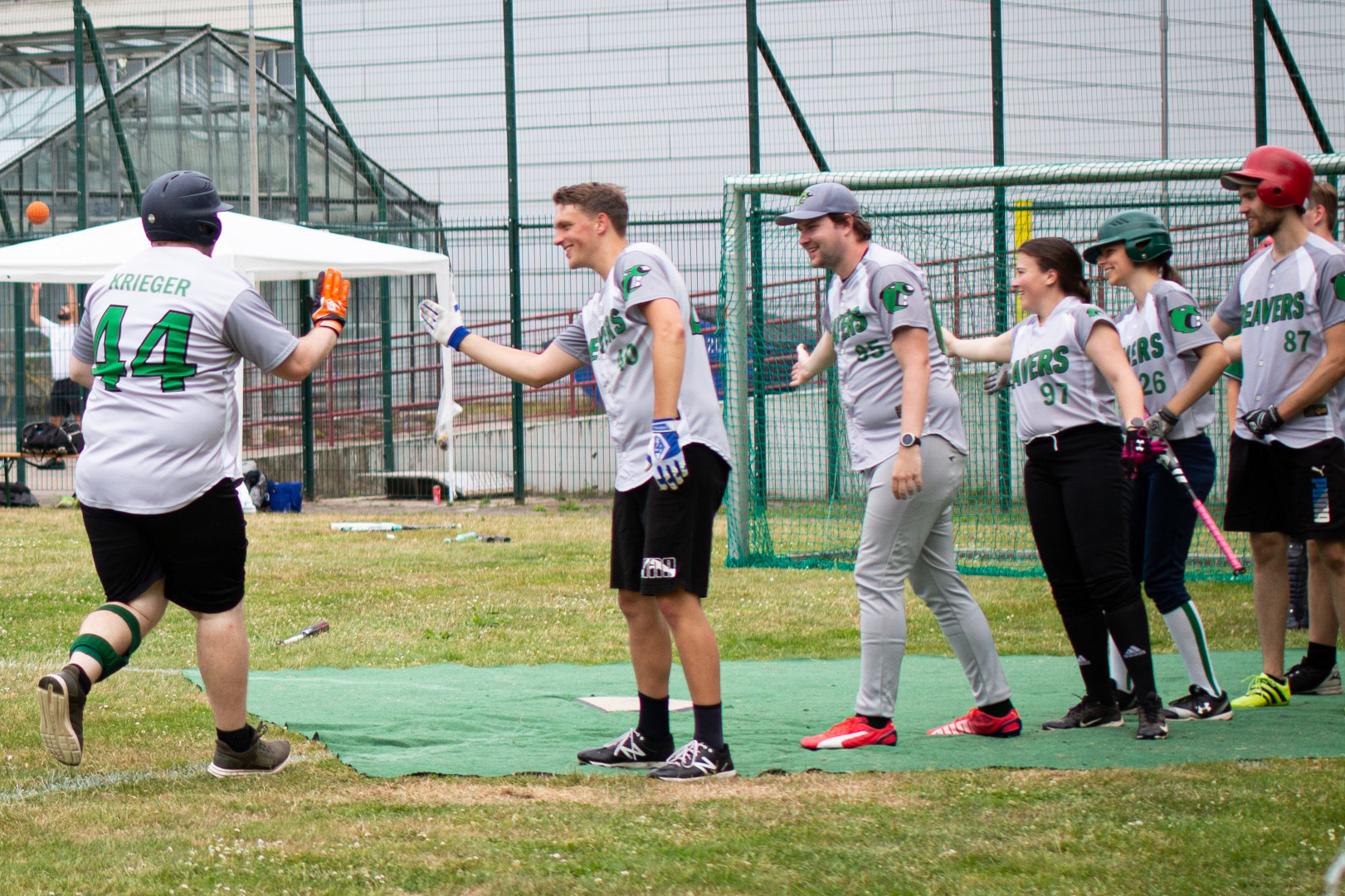 ein Spieler der Beavers läuft über die Homeplate, wo seine Teamkolleg*innen zum Abklatschen auf ihn warten