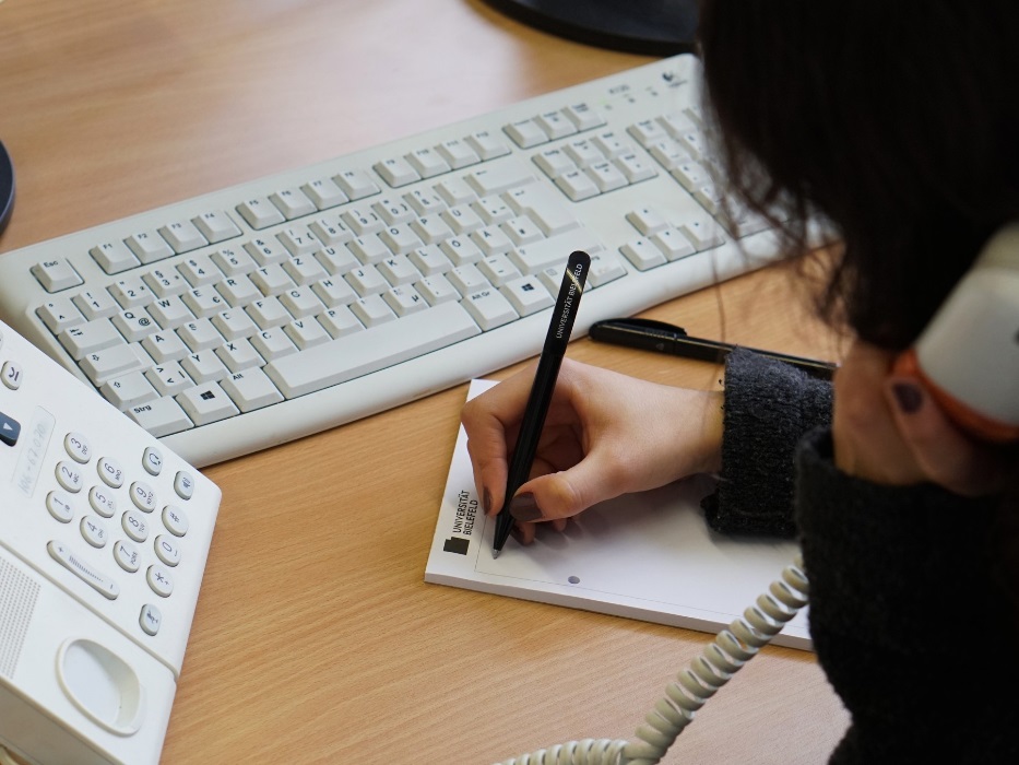 Person telefoniert und macht gleichzeitig Notizen