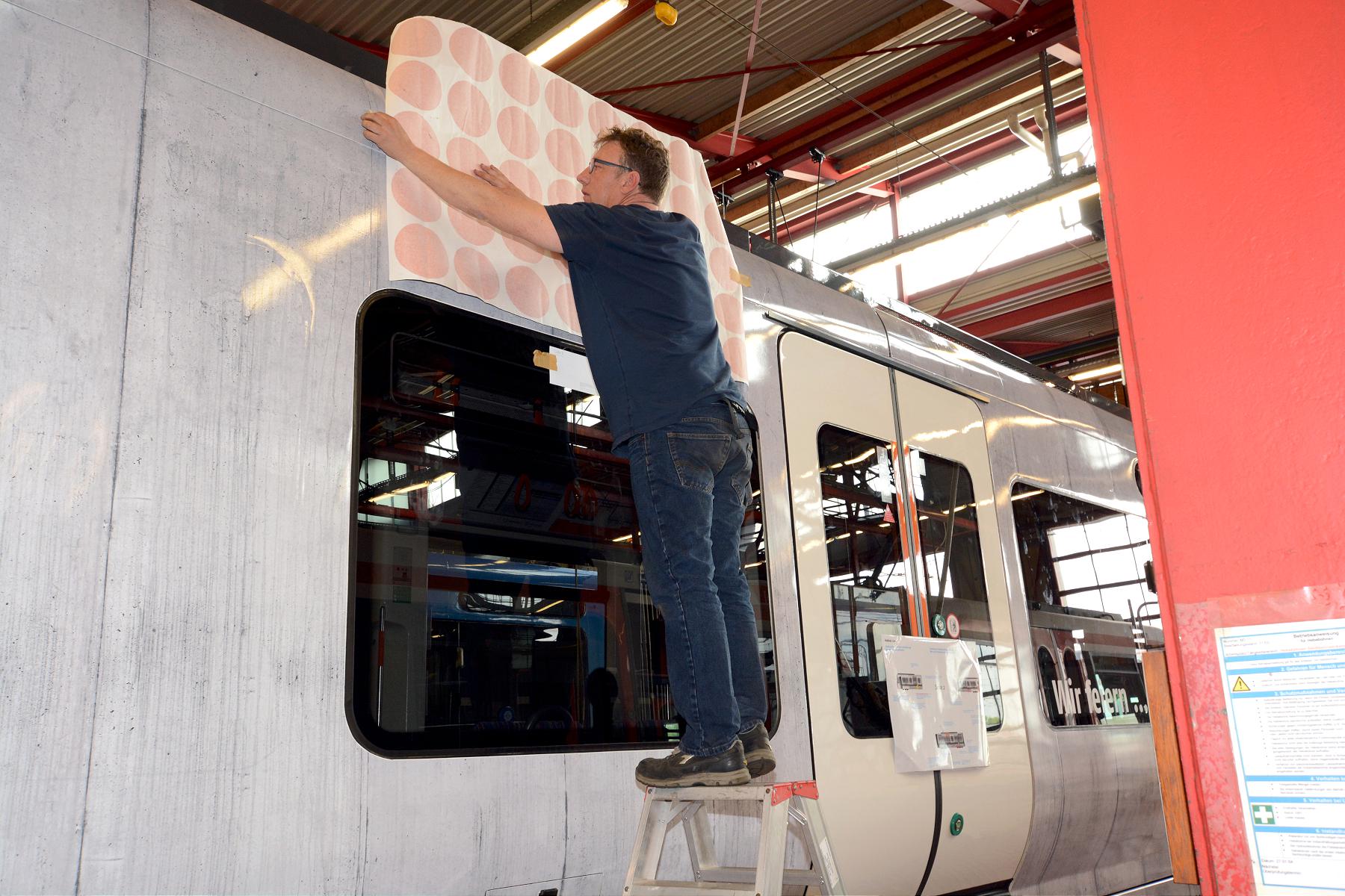 Bild von den Beklebungsarbeiten an dem Straßenbahnwagen