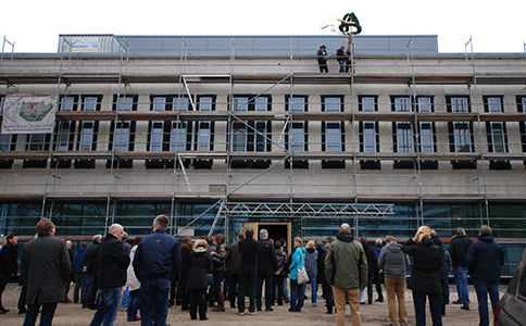 Menschen stehen vor dem Gebäude beim Richtfest