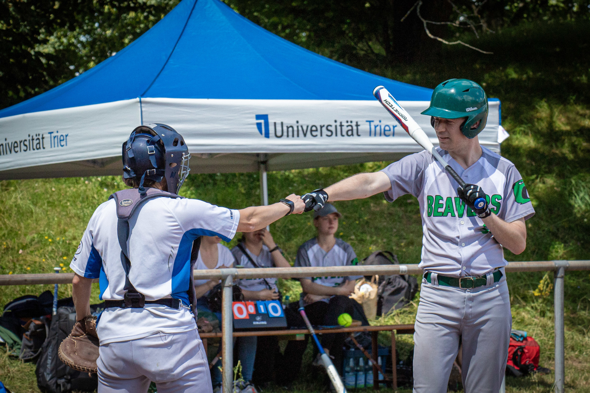 ein Batter der Beavers und die gegnerische Catcherin machen einen "fist bump"