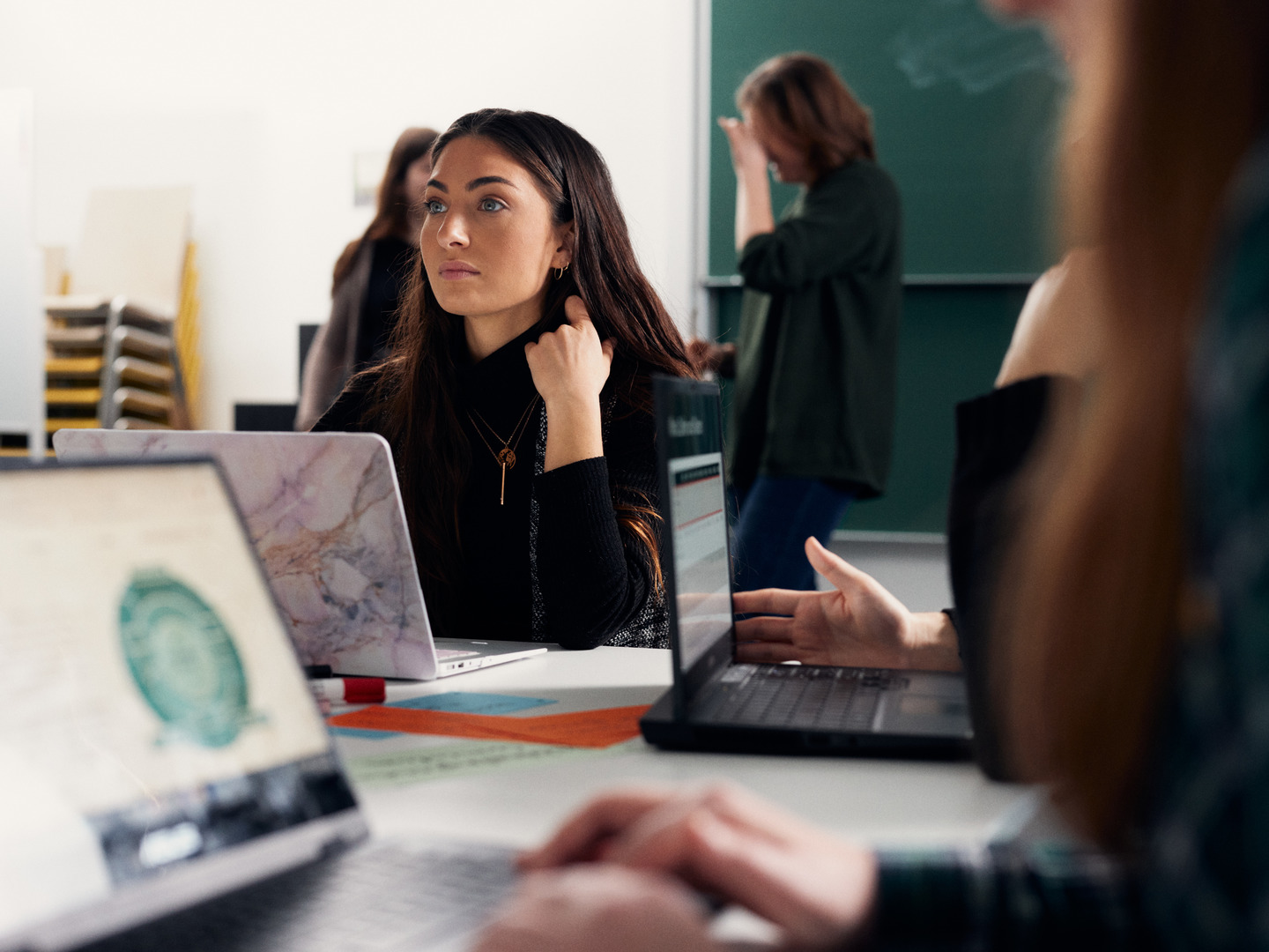 Eine junge Frau schaut konzentriert, vor ihr steht ein Laptop.