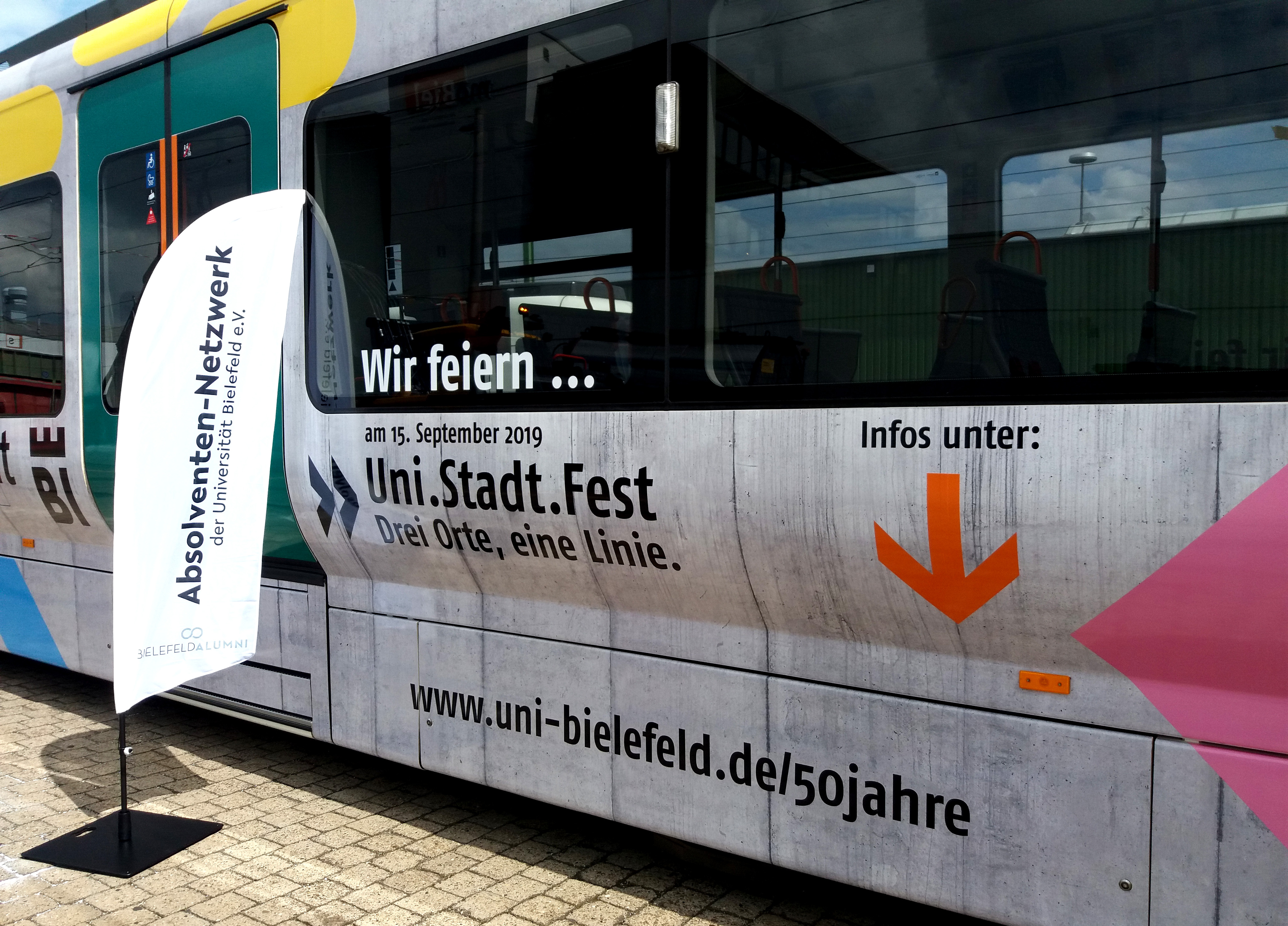 Bild zeigt einen Teil der Bahn. Es wird auf das Uni.Stadt.Fest am 15. September hingewiesen.