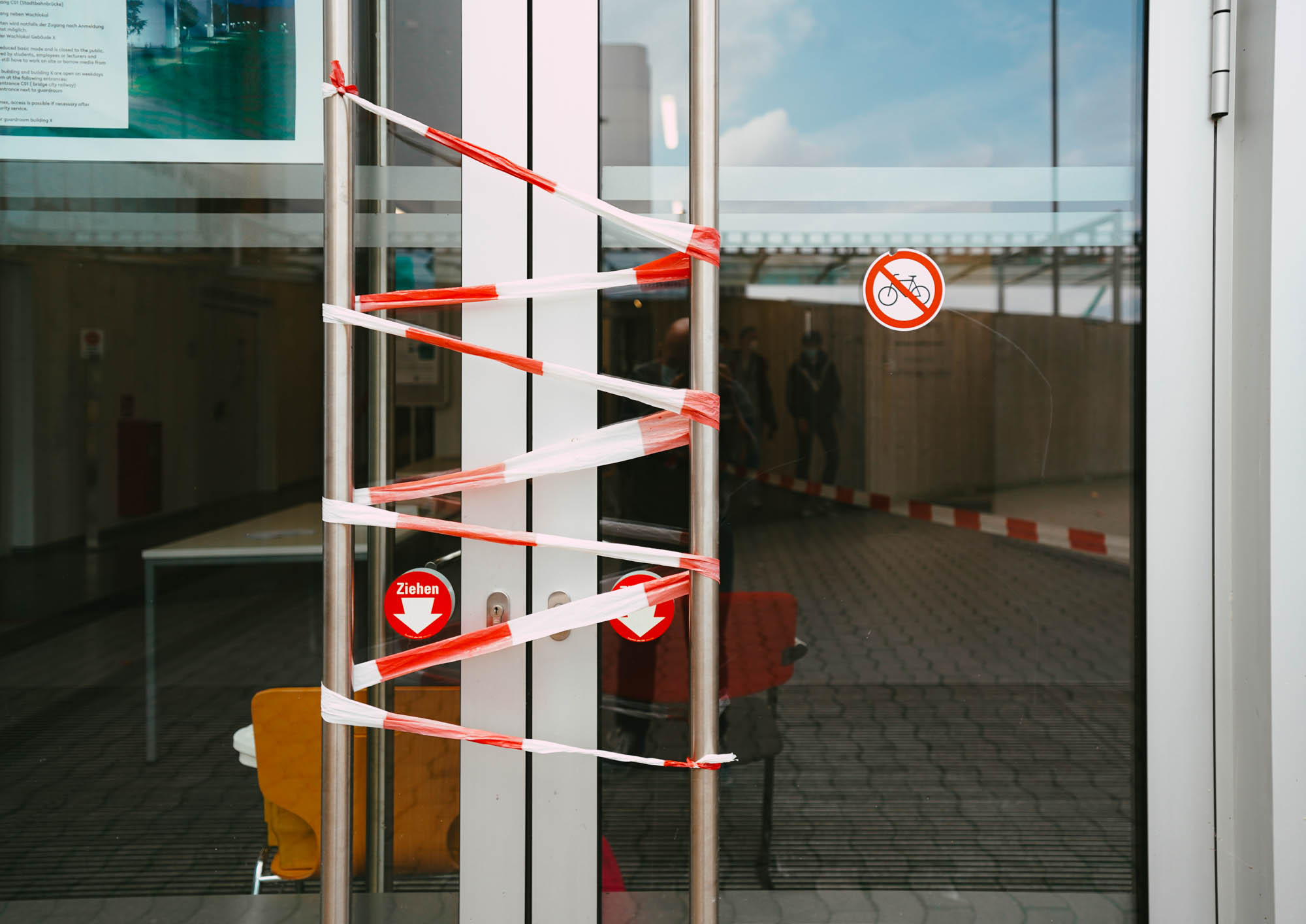 Die Eingangstüre der Universität Bielefeld mit rot-weißem Flatterband abgesperrt