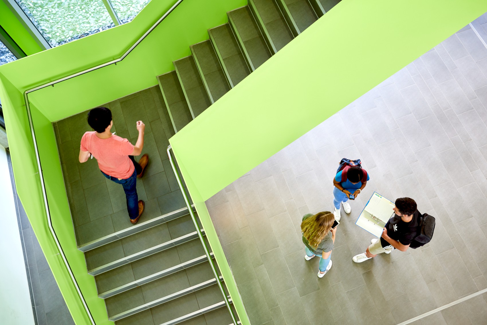 Studierende laufen eine grüne Treppe hoch